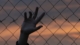 Hand on Chain Link Fence
